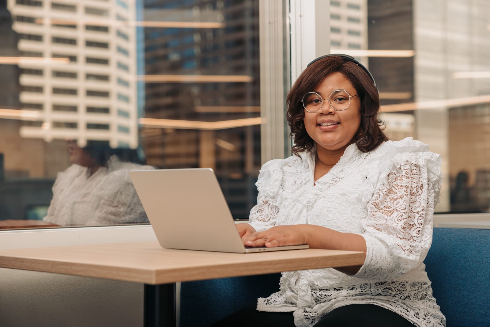 A young woman wearing headphones working on a laptop, representing future technology initiatives.